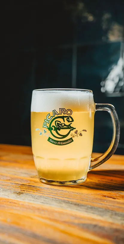 Chope de bière artisanale sur une table en bois.