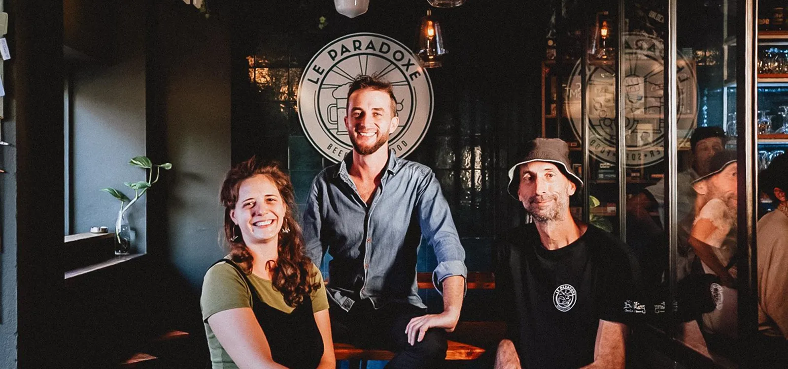 Trois personnes souriantes posant devant un logo "Le Paradoxe".