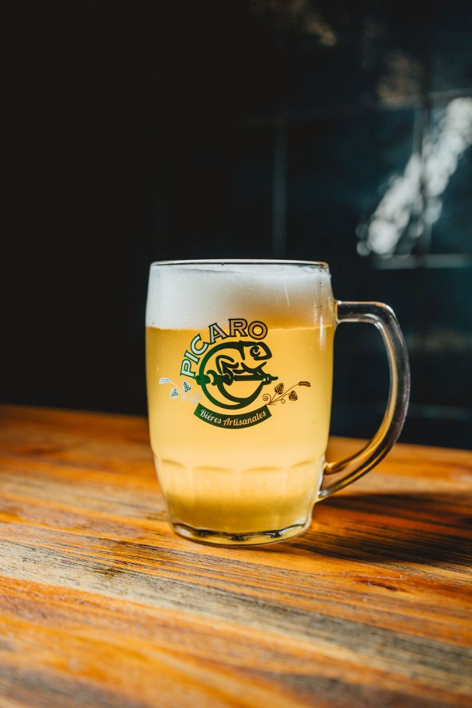 Chope de bière artisanale "Picaro" sur une table en bois.
