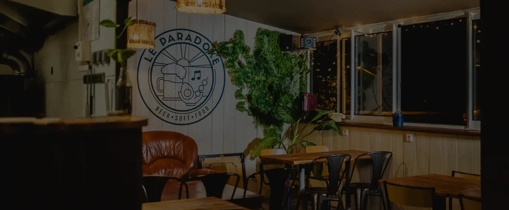 Intérieur d'un café avec logo "Le Paradoke" sur le mur.